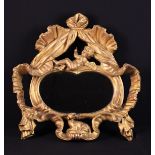 A 19th Century Oval Wall Mirror set in an open carved giltwood frame.