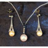 A Pearl Pendant on an 18 Carat white gold mount set with four small diamonds and hanging from a 9