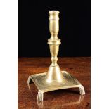 An 18th Century Spanish Cast Brass Candlestick with knopped stem and square tray base raised on