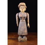 A 19th Century Carved & Polychormed Folk Art Figure of a woman wearing a hat, with swinging arms,