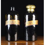 A Pair of Large Early 19th Century Black Glass Chemist Jars with gilded labels;