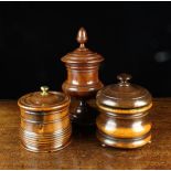 Three 19th Century Turned Treen Lidded Jars: A moulded lignum vitae jar on three small squat bun