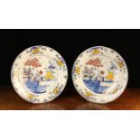 A Pair of 18th Century Dutch Delft Chargers painted in polychrome with chinoiserie garden scenes to