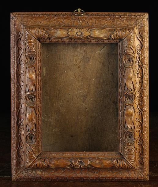 A Fine Intricately Carved Picture Frame ornamented with a raised garlands of roses and layered