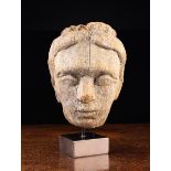 A Carved and Weathered Wooden Head 7" (18 cm) in height, mounted on a modern display stand.
