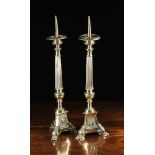 A Pair of Polished Brass Pricket Candlesticks with reeded urn-knopped stems above triform bases