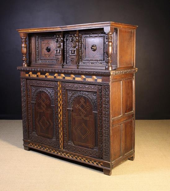 A 19th Century Jacobean Style Inlaid Oak Court Cupboard enriched with carving and inalid with