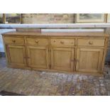 A Victorian pine dresser base with four drawers and four cupboard doors, 92cm H x 245cm W x 53cm D -