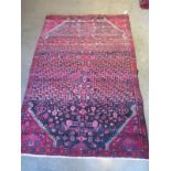 A hand knotted woollen rug with graduating colours, 195cm x 128cm