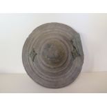 A hand held Eastern wooden punch shield, 21cm diameter, 12cm tall, general wear, repair to edge