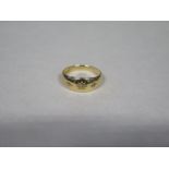 An 18ct gold ring, inset with three small diamonds, approx 2.8 grams, size N, some surface scratches