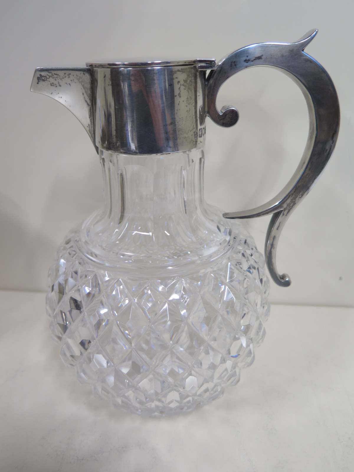 A cut glass claret jug with silver top - London WC JL 1898/99 - 19cm tall - generally good condition