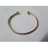 A 9ct yellow gold bangle, 6cm wide, approx 8.5 grams, minor usage