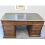 A good quality antique style oak free standing pedestal desk with seven active drawers and two