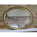 An early 20th Century gilt oval mirror, 69cm x 55cm