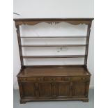 A good quality Georgian style oak dresser by Simon Simpson of Norwich with an open rack top above