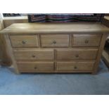 A solid oak three over four chest of drawers - W140cm x D42cm x H77cm