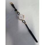 A 9ct ladies Omega wristwatch on black leather strap, manual wind 28mm wide including button,