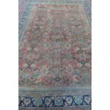 A hand knotted woollen rug with light red ground, approx 362cm x 255cm, in used condition, with some