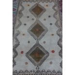 A small hand knotted woollen rug with three diamond forms to its centre - approx 201cm x 118cm