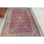 A hand knotted woollen rug from Iran, 382cm x 265cm - some patches of wear, colours bright