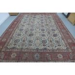 A hand knotted woollen rug with an ivory field from Iran - 470cm x 308cm - some patches of wear,