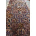 A hand knotted woollen rug with geometric and floral designs, approx 336cm x 186cm, in good