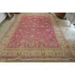 A hand knotted woollen rug from Iran - with a red field - 398cm x 291cm - no obvious holes