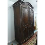 An 18th/19th Century walnut Armoire with carved arched doors, needs dome restoration, rear feet