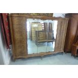 A burr walnut five door continental wardrobe with three mirrored doors, all enclosing hanging