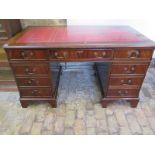 A mahogany pedestal desk with a leather inset top over nine drawers, 136cm H x 77cm W x 76cm D