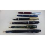 Six fountain pens including three with 14ct gold nibs, a Montmore, a Burnham and a De La Rue,