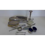 An assortment of silver items, silver backed hair brushes, pair of salts, a pair of pickle forks,