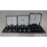 A cased set of six silver and enamel teaspoons with two other cased sets of silver coffee spoons,