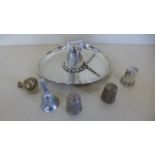 A mixed silver lot comprising of three silver thimbles a miniature silver bell ornately embossed,