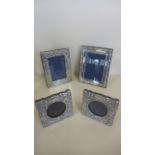 A collection of four silver photograph frames including a pair of small square frames, overall