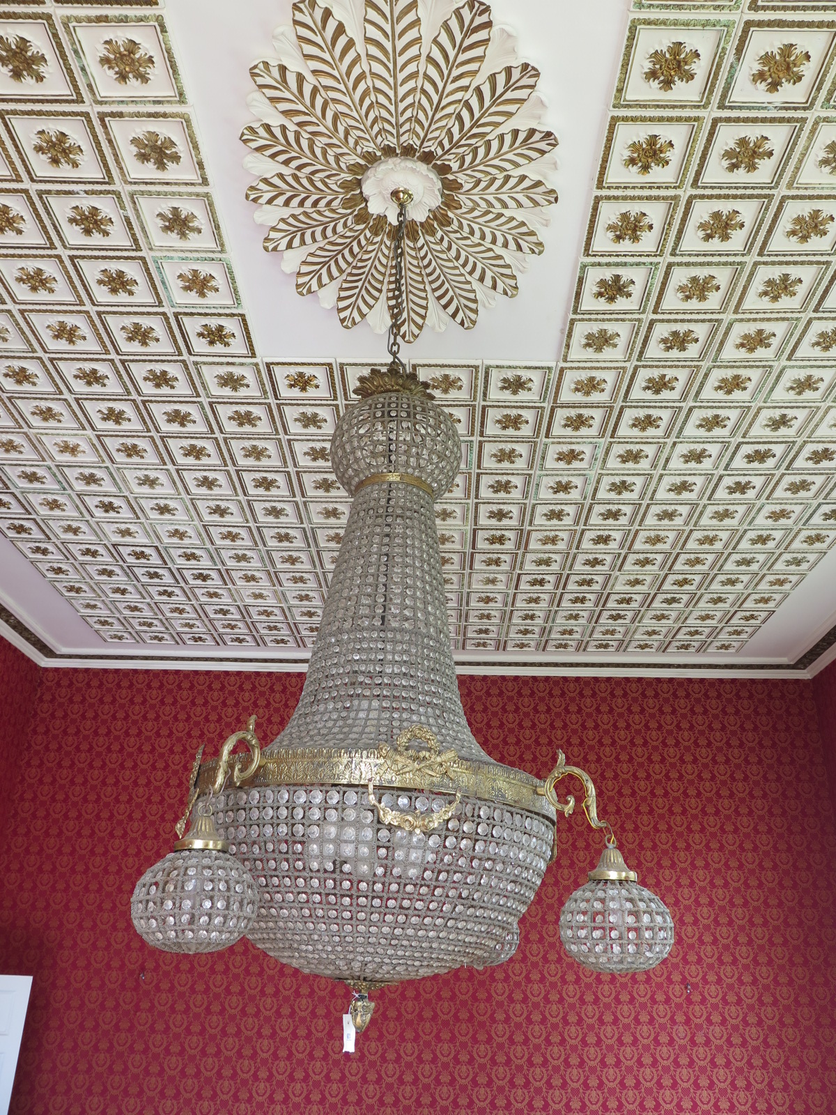 A large gilt chandelier, with ten central lights, with hanging glass drop, with four outer