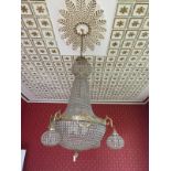 A large gilt chandelier, with ten central lights, with hanging glass drop, with four outer