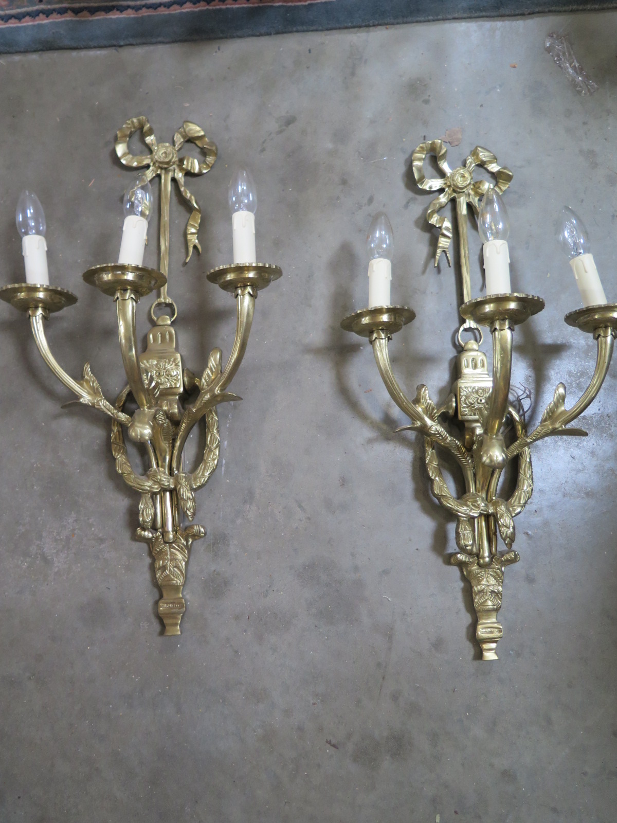 A pair of good quality brass three branch wall lights, 68cm high