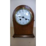 An 8 day French mantle clock, strikes hours and half hours, in an oak inlaid case - 24cm tall