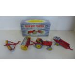 A Dinky Toys farm tractor and hay rake 310 with original blue and white box, also a disc harrow