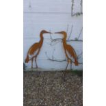 A pair of life size metal garden silhouettes of herons with ground stakes, 92cm high excluding