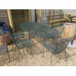 A metal oval table with six matching armchairs