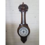 A carved oak aneroid barometer with thermometer - 90cm long