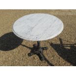 A marble-topped circular cafe table with a cast iron base - approx 75cm diameter