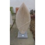 A limestone hand carved abstract sculpture, with a blue limestone base - approx 68.5cm high