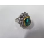 An impressive diamond ring, with a central emerald colour glass measuring approx 11mm x 9mm x