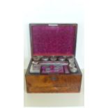 A burr walnut travel case with white metal and cut glass dressing table, pots and accessories,