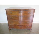 A mahogany serpentine fronted secretaire chest with a fitted drawer above three further drawers on