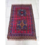 A hand knotted woollen new Baluchi rug - approx 135cm x 86cm - in good condition